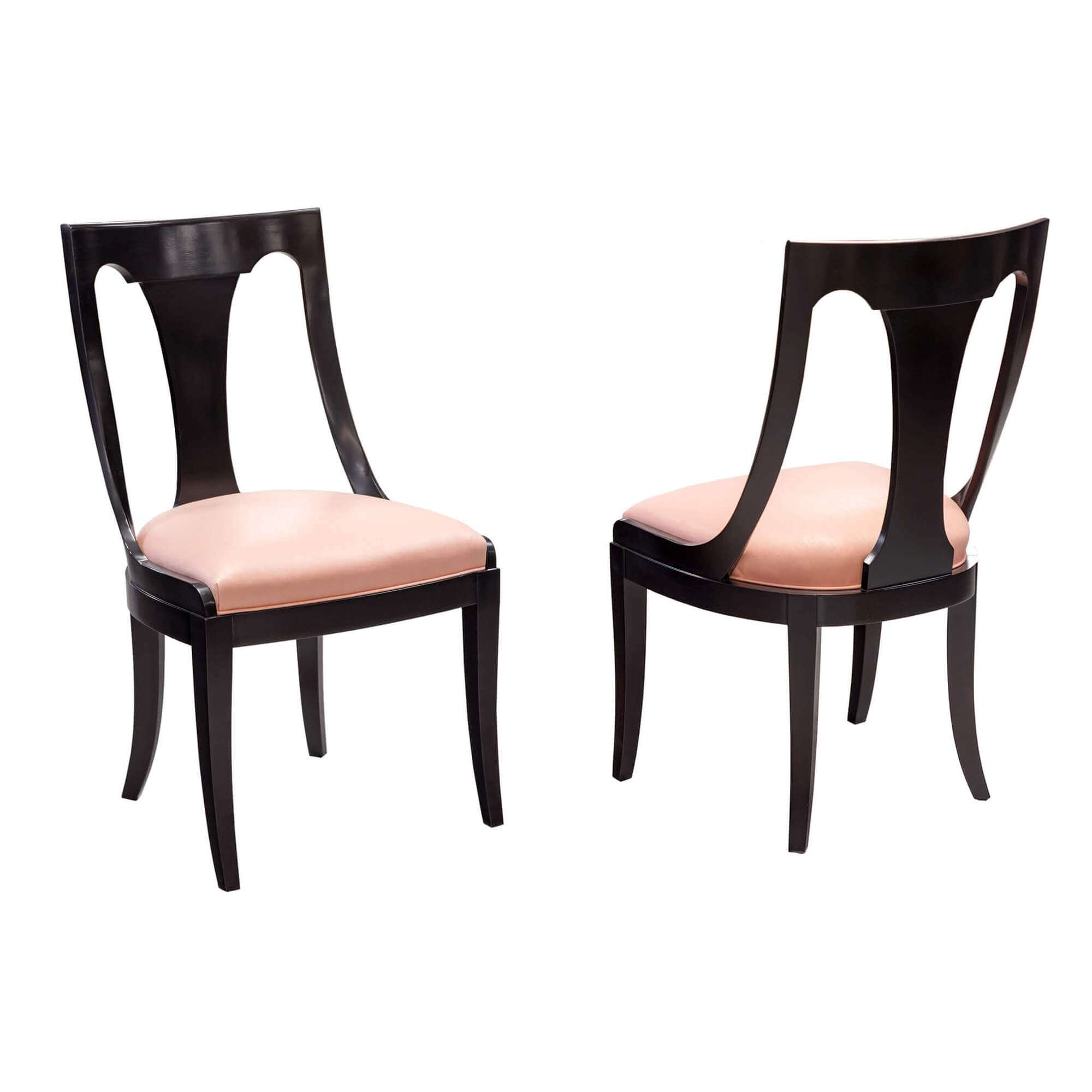 Pair of dark wood dining chairs, pink cushions.