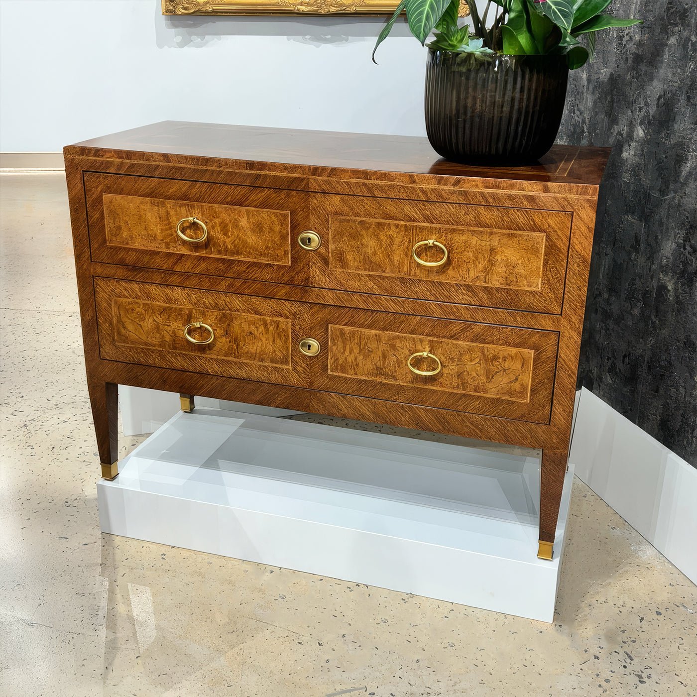 Corner view of antique style chest of drawers on display.