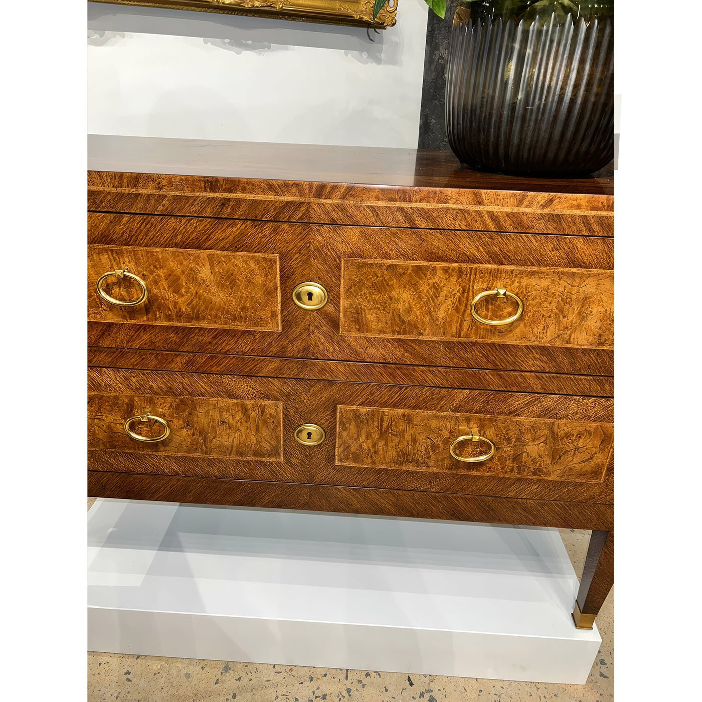 Front view of antique style chest with decor items.