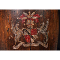 Detailed emblem on wooden barrel accent table surface.