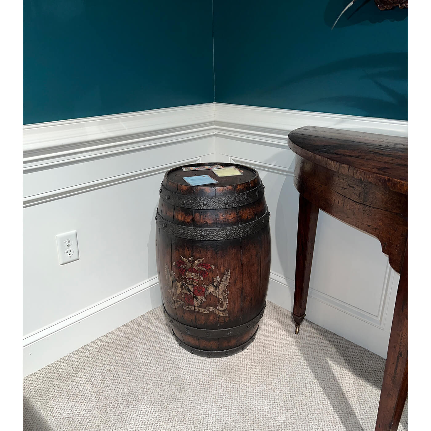 Wooden barrel accent table in corner, beside wooden desk.