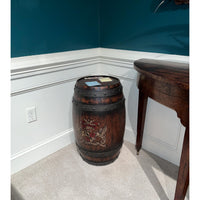 Wooden barrel accent table in corner, beside wooden desk.