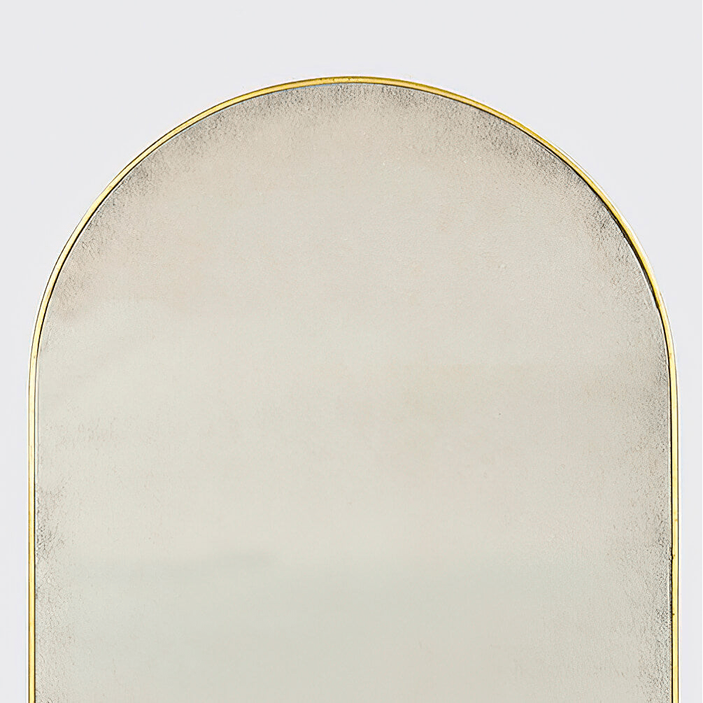 Close-up of top section of arch mirror, gold trim.