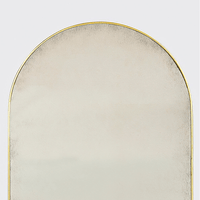Close-up of top section of arch mirror, gold trim.