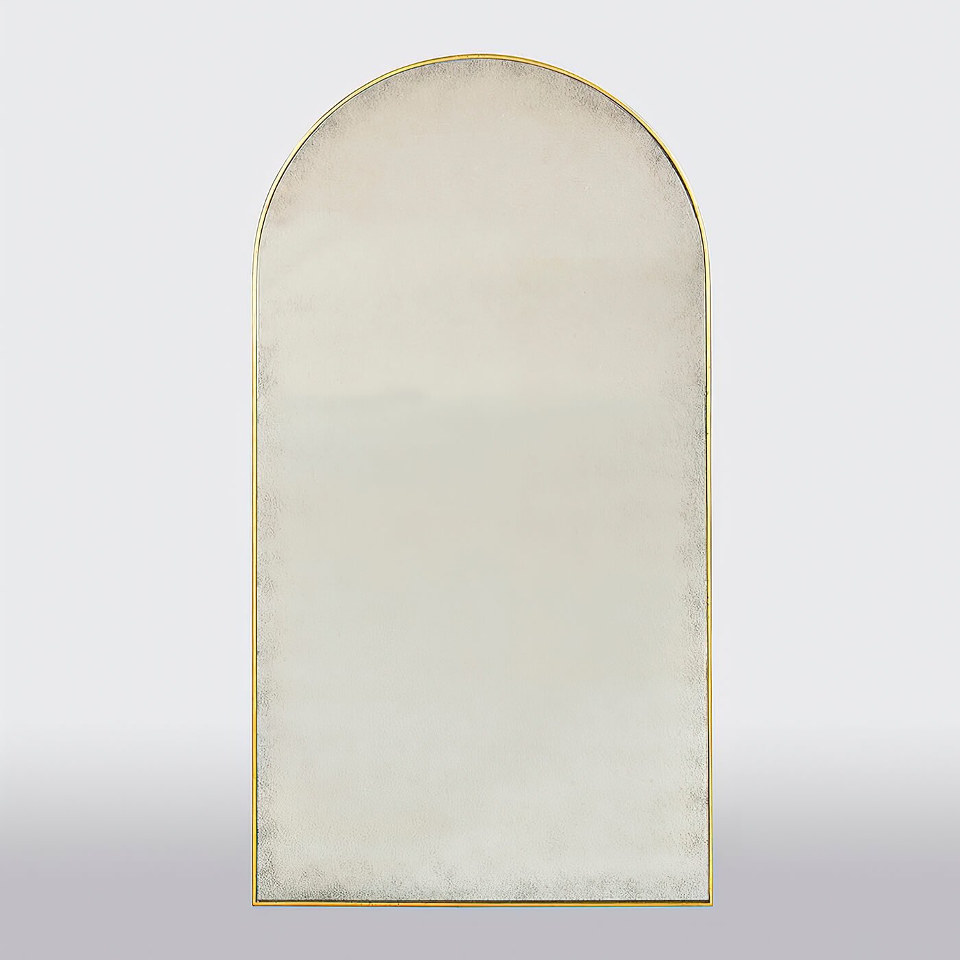 Front view of arch top gilt mirror, plain background.