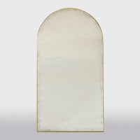 Front view of arch top gilt mirror, plain background.