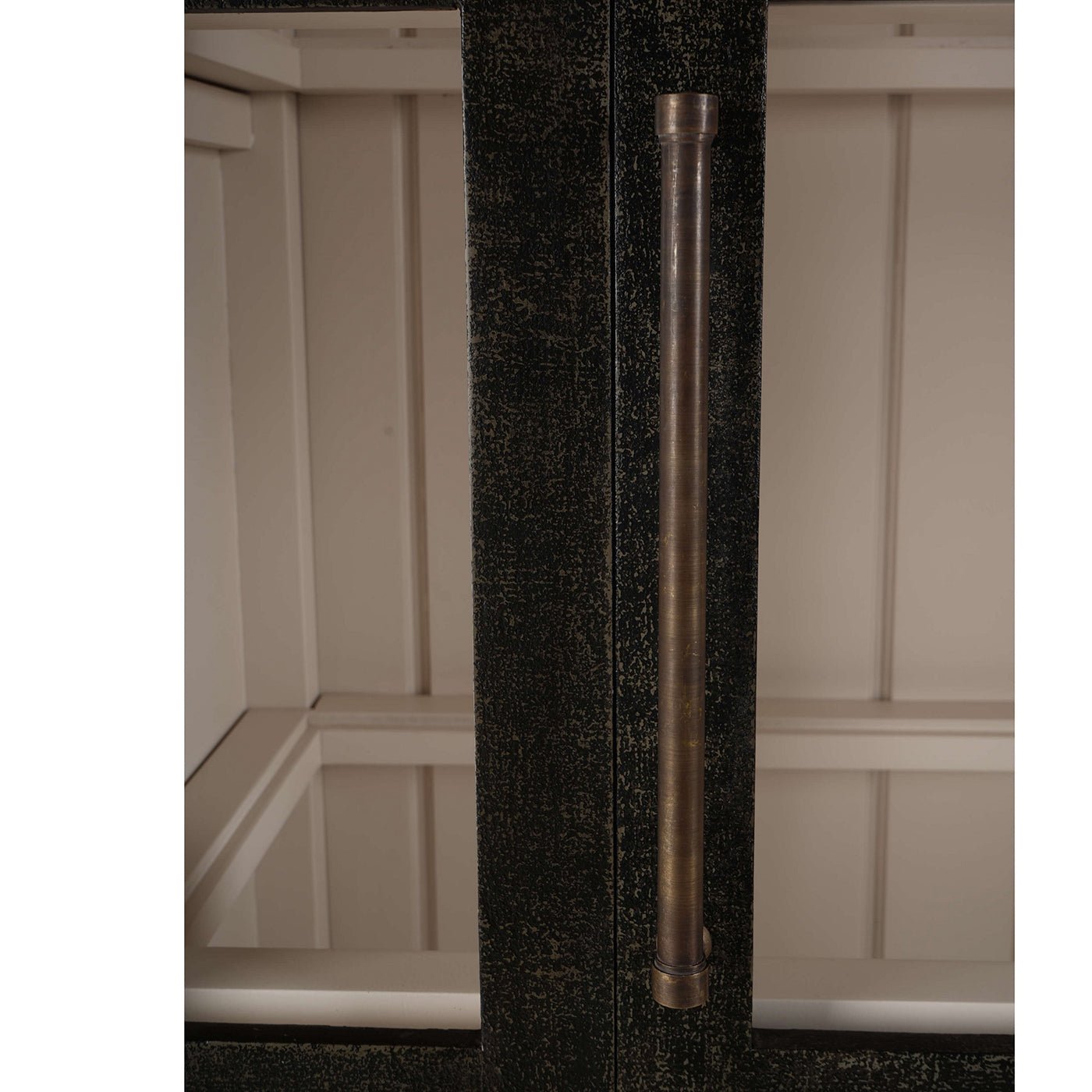 Arched display cabinet handle close-up, vertical orientation.