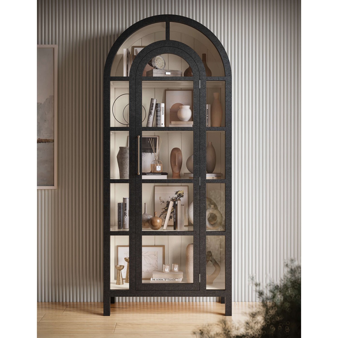 Arched display cabinet styled, art and decor arranged inside.