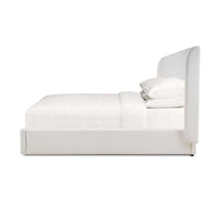 White upholstered king size bed side profile view.