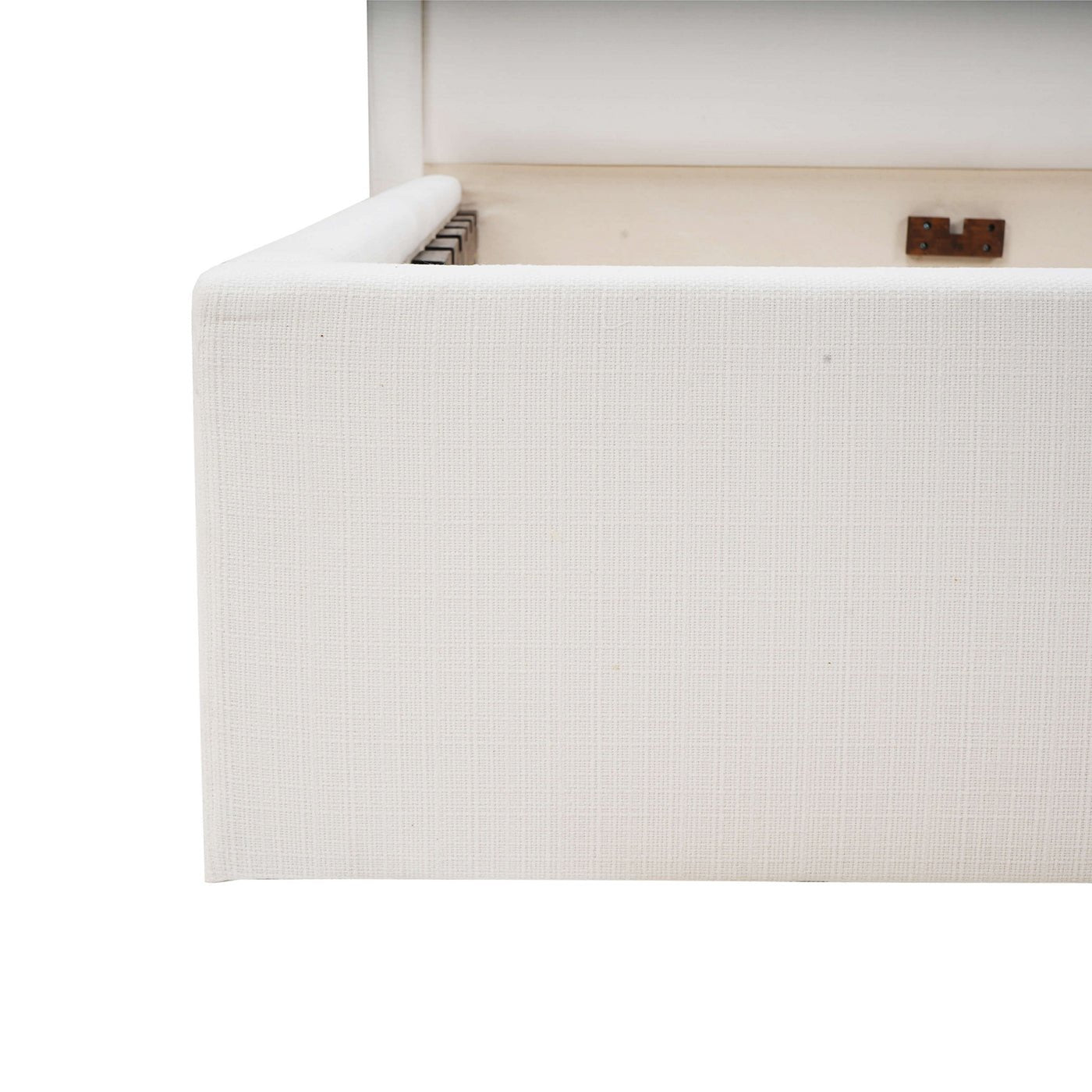 Corner view of white upholstered bed frame details.