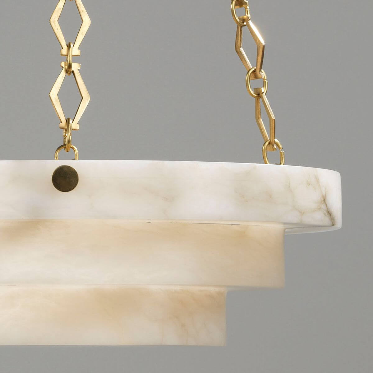 Close-up of chandelier's alabaster tiers and brass accents.