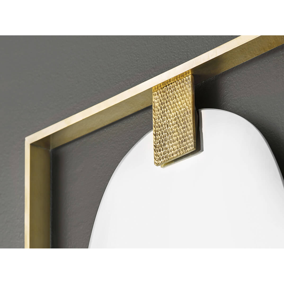 Close-up of brass detail on wall mirror frame.