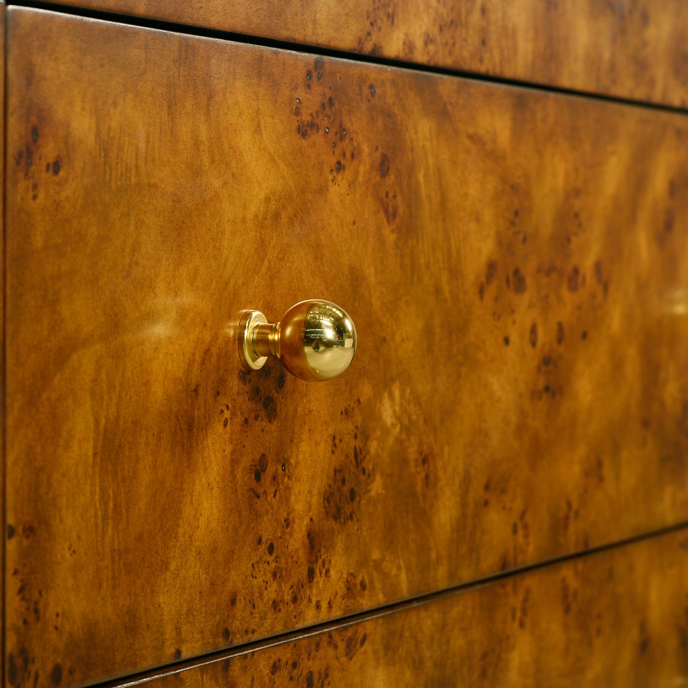Drawer knob detail on Art Deco burl chest, gold hardware.