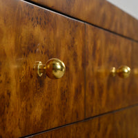Art Deco burl dresser drawers, gold knobs close-up.