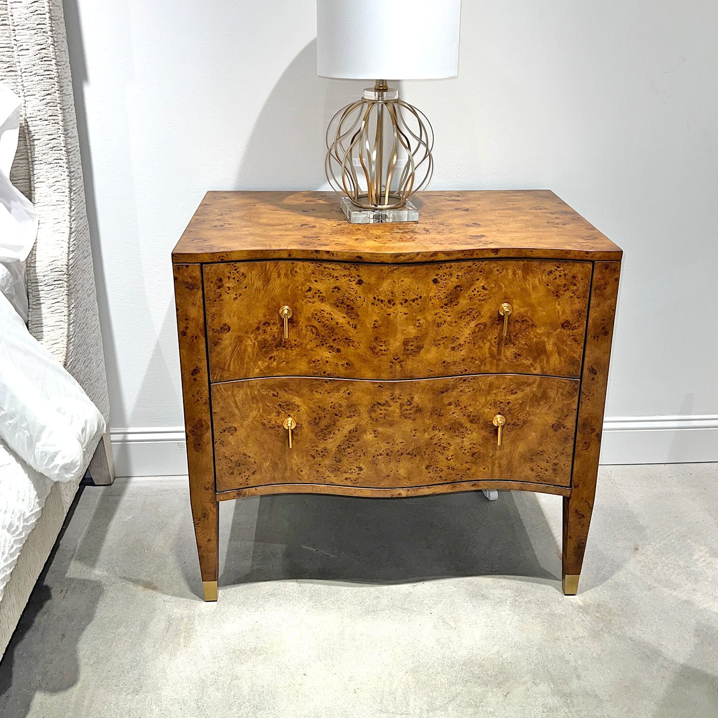 Burl nightstand styled in a room, with a lamp on top.