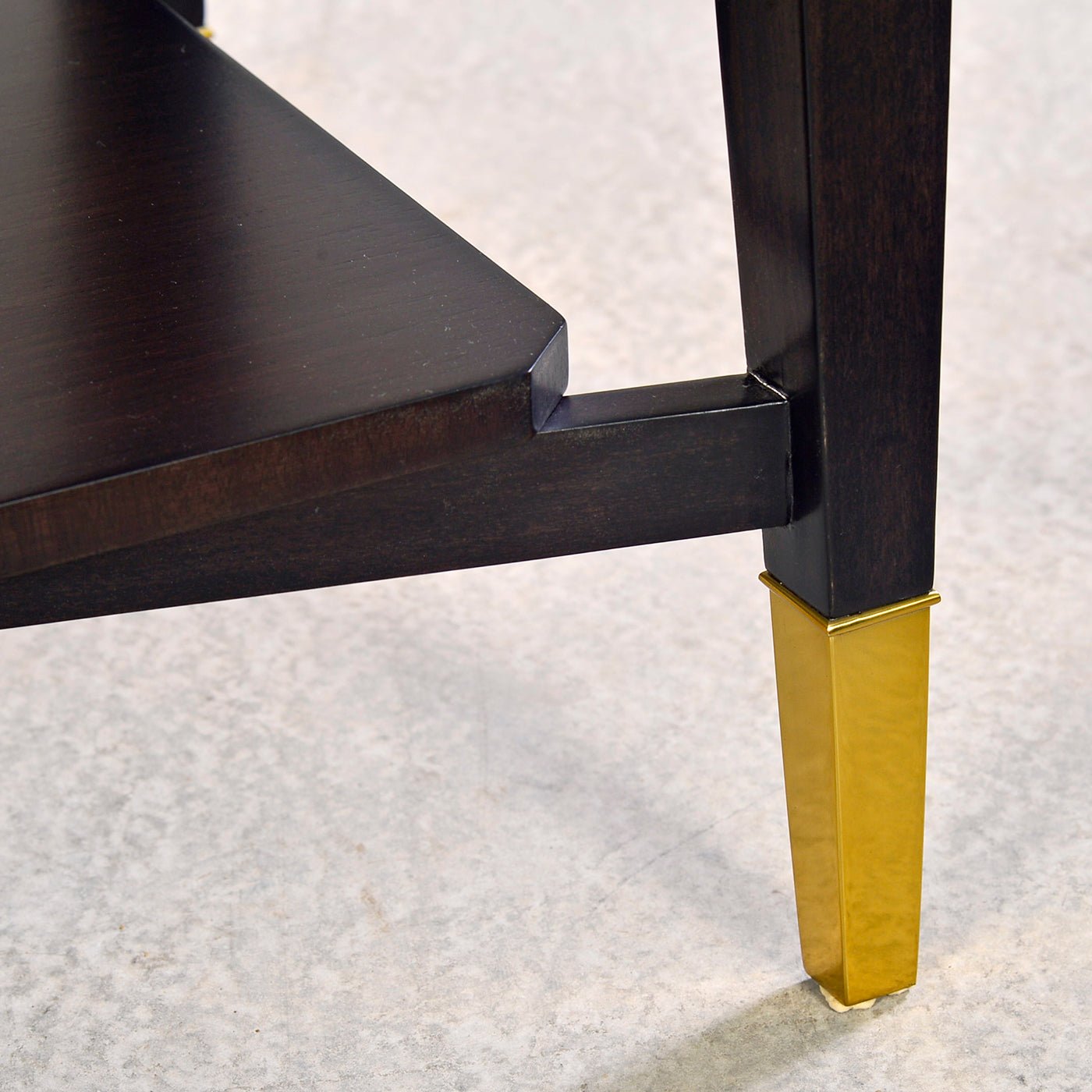 Close-up of console table leg with gold-capped foot.