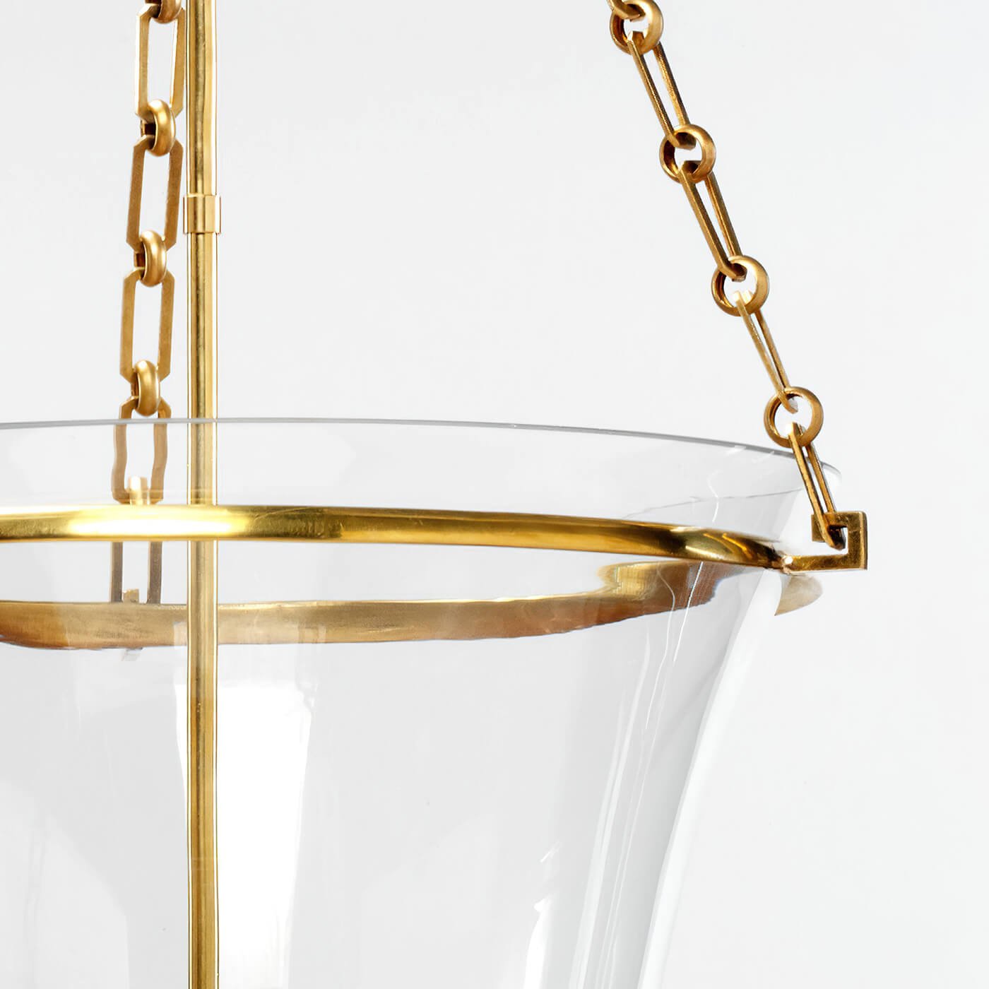Cloche lantern focus, brass chain and glass rim close-up.