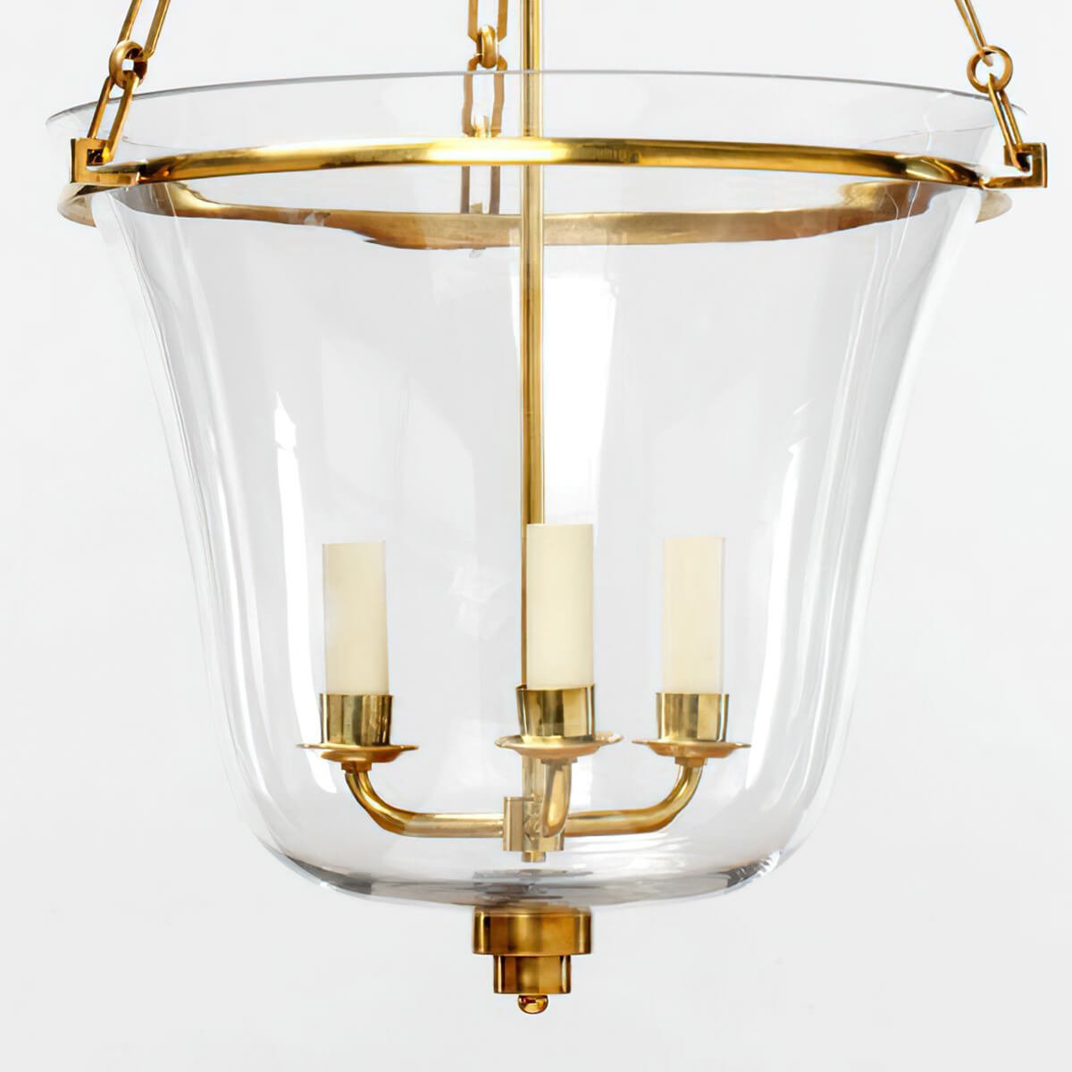 Brass lantern close-up, showing candle-style lights and glass.