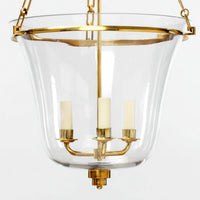 Brass lantern close-up, showing candle-style lights and glass.