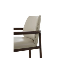 Close-up of beige leather dining armchair, arm and back detail.