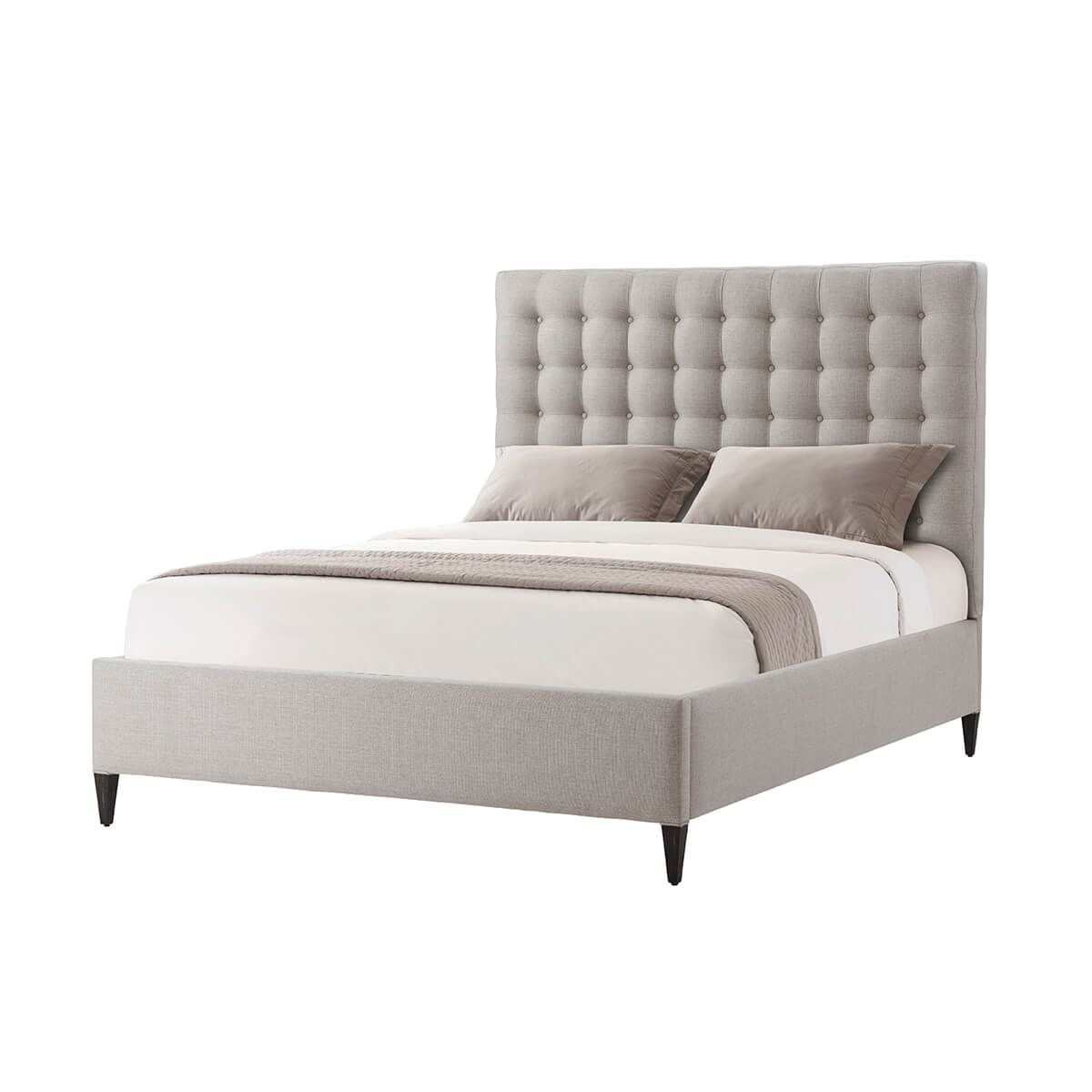 Gray tufted queen bed with bedding, angled view.