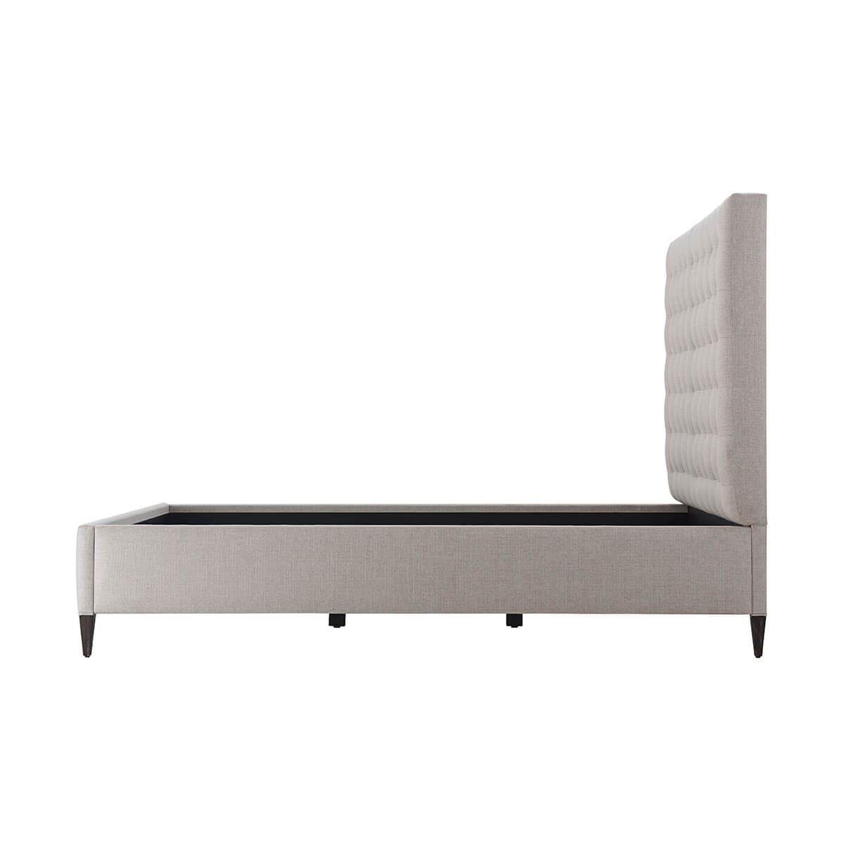 Side profile of gray tufted queen bed frame.