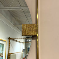 Detailed view of textured gold accent on mirror.