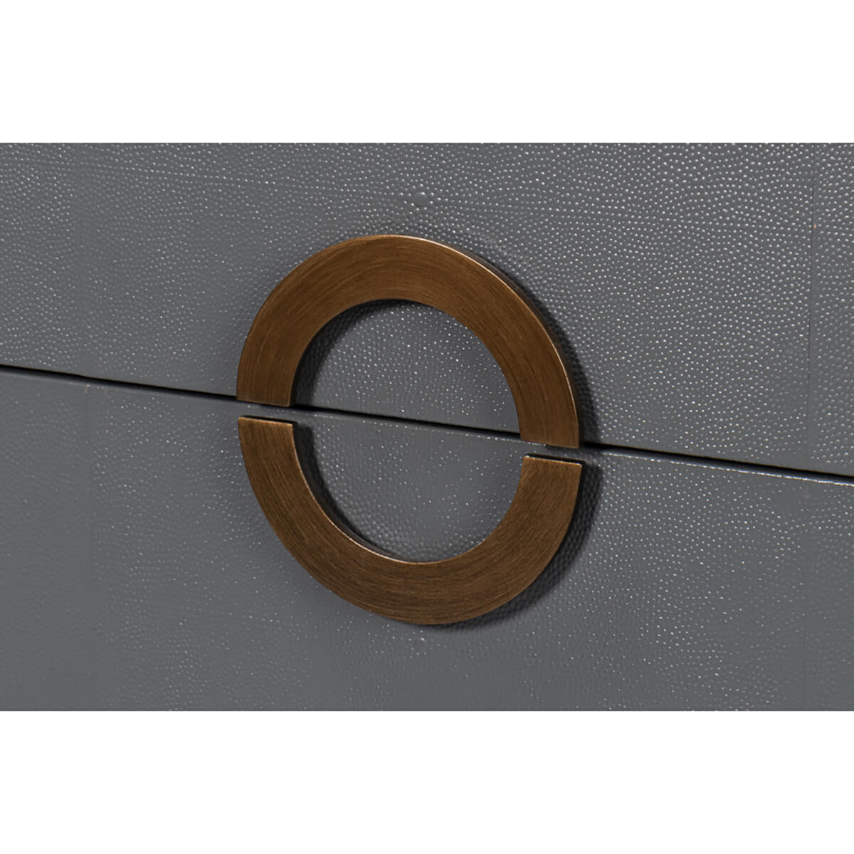 Close-up brass handle on grey dresser.