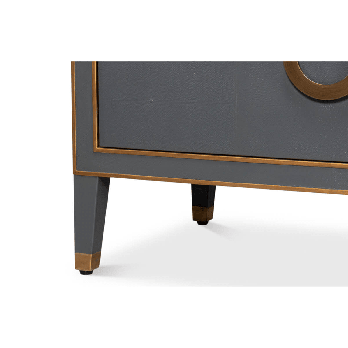 Close-up grey dresser leg, brass trim.