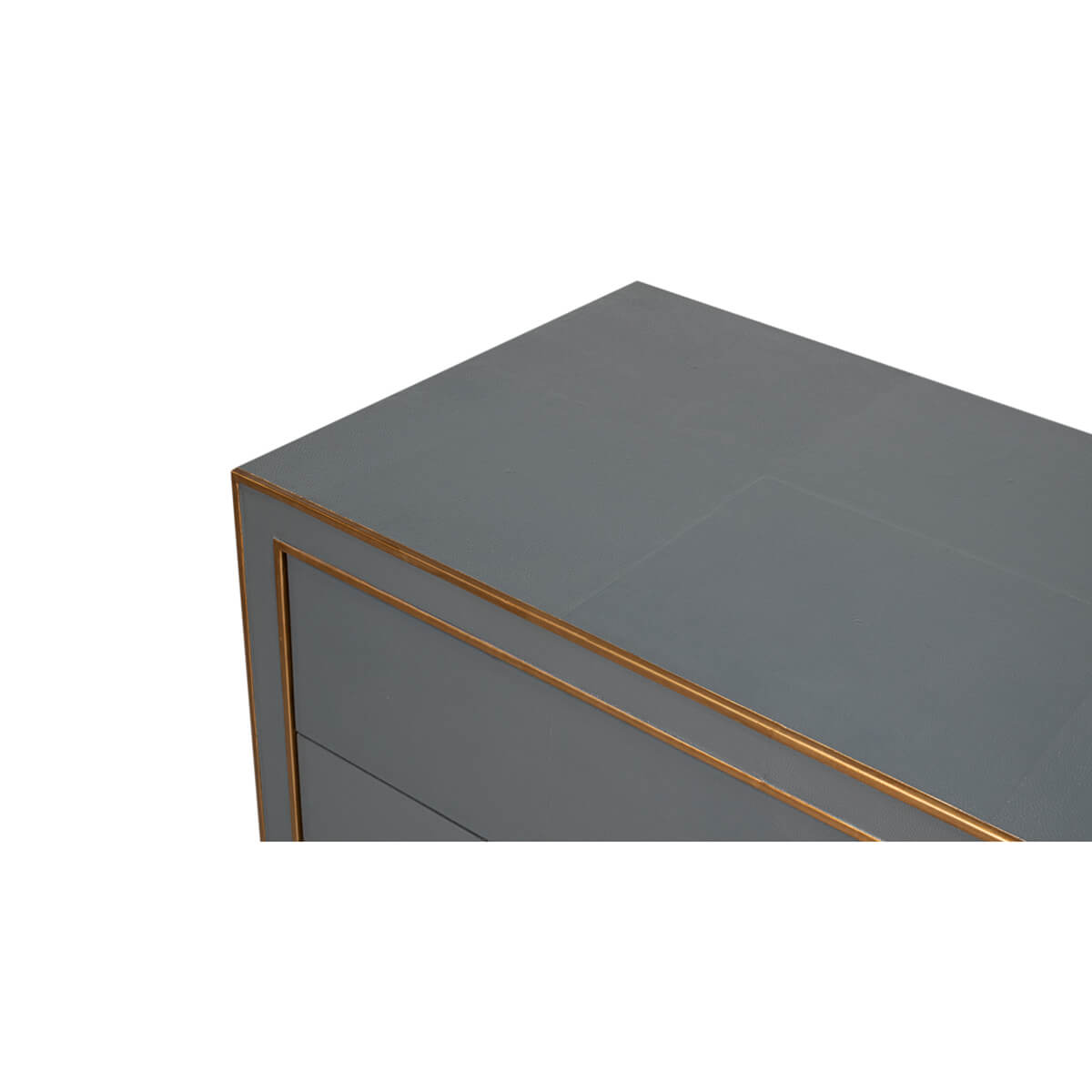 Close-up grey dresser corner, brass trim.