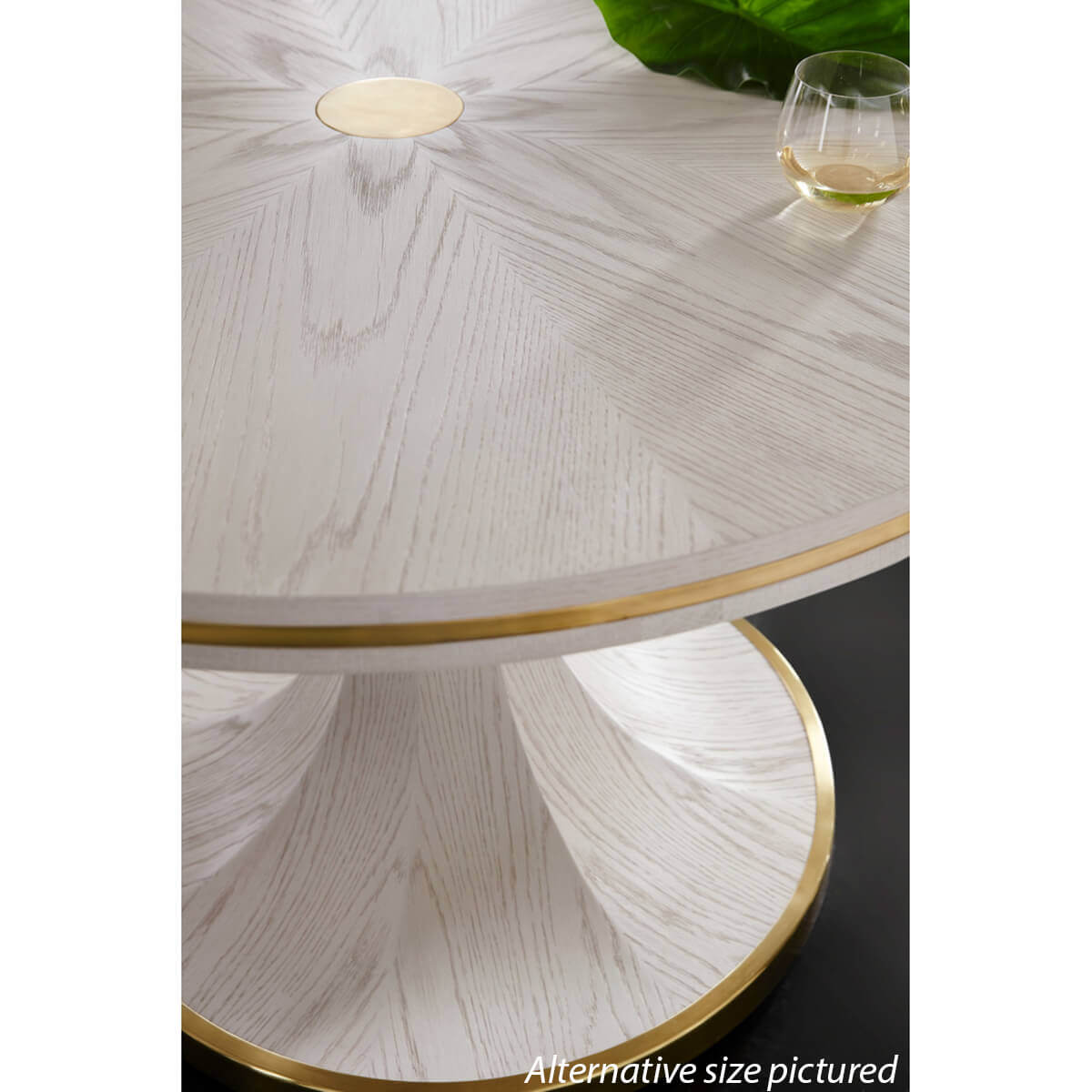 Close-up of white dining table with brass detail.