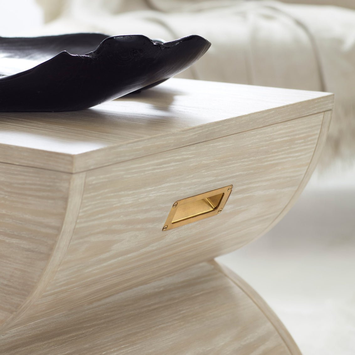 Close-up of geometric accent table with gold handle.