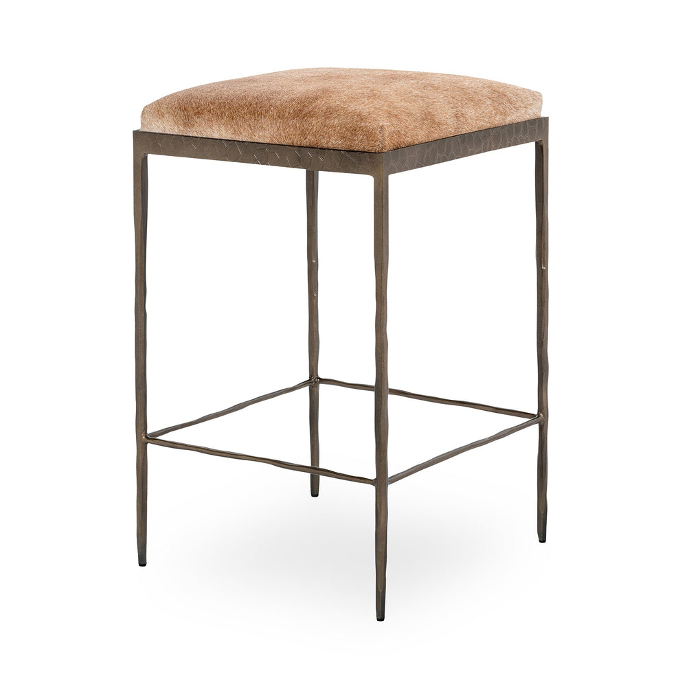Three-quarter view of tan backless hair-on-hide counter stool with a square seat and hammered iron frame.