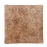 Top view of the square tan hair-on-hide seat with natural color variation.
