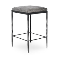 Three-quarter view of gray backless hair-on-hide counter stool with a square seat and black iron frame.