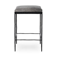 Straight-on view of gray backless hair-on-hide counter stool with slim black iron legs and footrails.