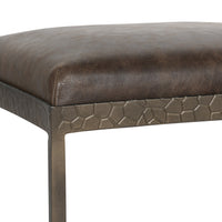 Close-up of the dark brown leather seat corner and textured iron apron on the backless counter stool.