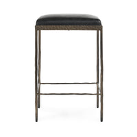 Straight-on view of black backless leather counter stool with slim hammered iron legs.