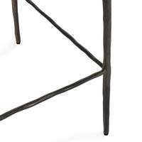 Detail of the hammered iron legs and footrail joints on the black backless counter stool.