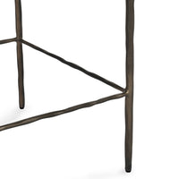 Detail of the hammered iron legs and footrail joints on the tan backless counter stool.