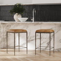 Two tan backless leather counter stools beside a marble kitchen island.