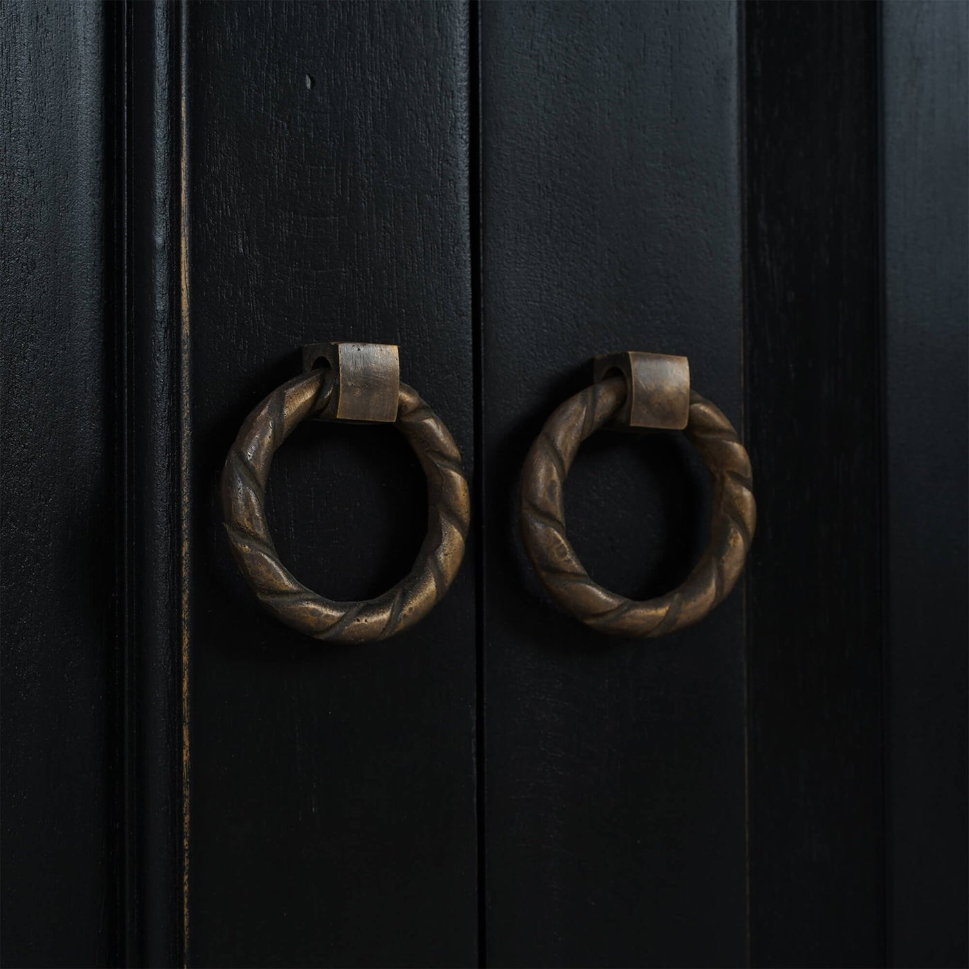 Close-up of ornate door handles on sideboard.