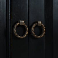 Close-up of ornate door handles on sideboard.