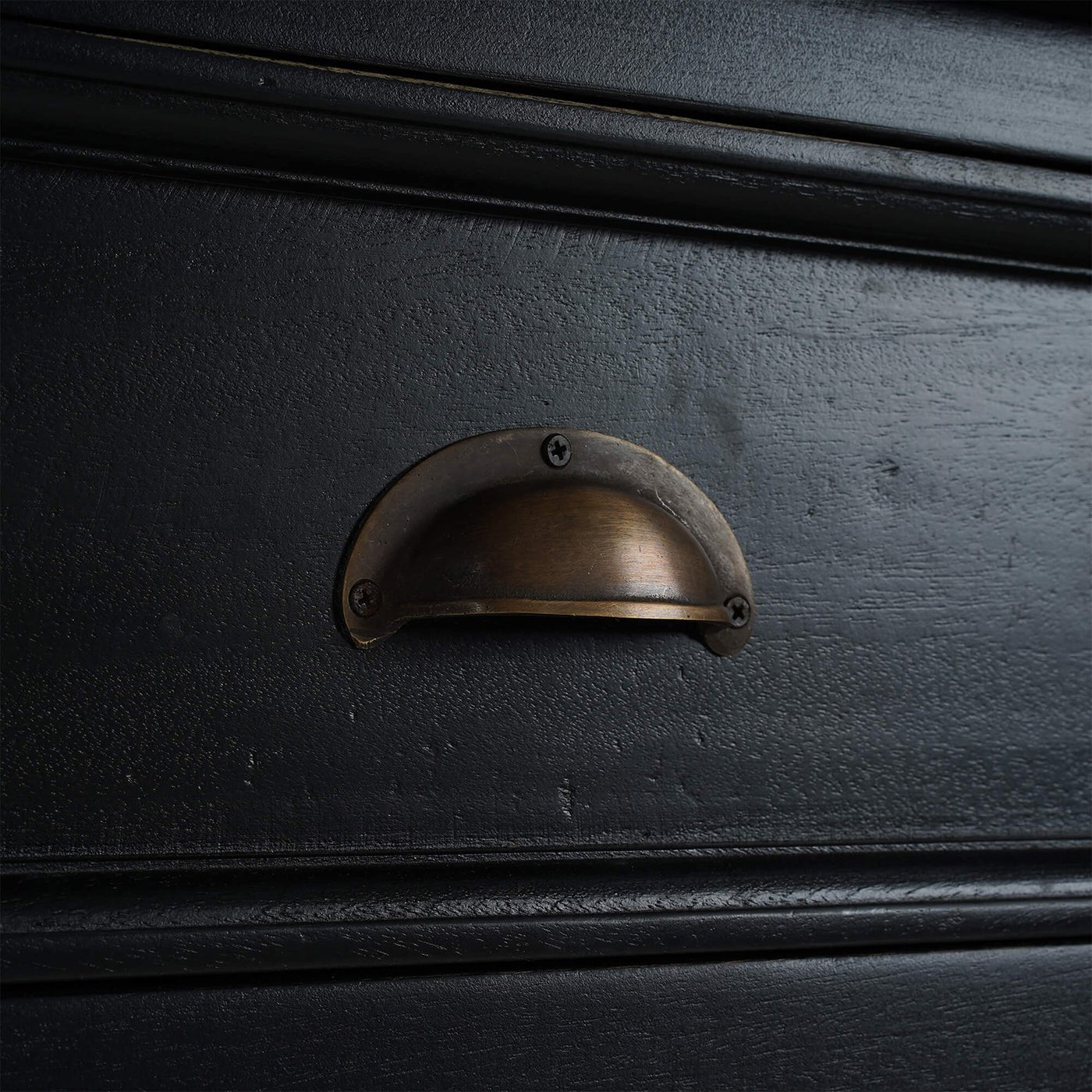 Detailed view of black sideboard drawer handle.