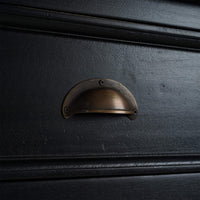 Detailed view of black sideboard drawer handle.
