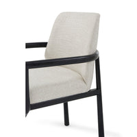 Black dining armchair, close-up, beige fabric and frame.