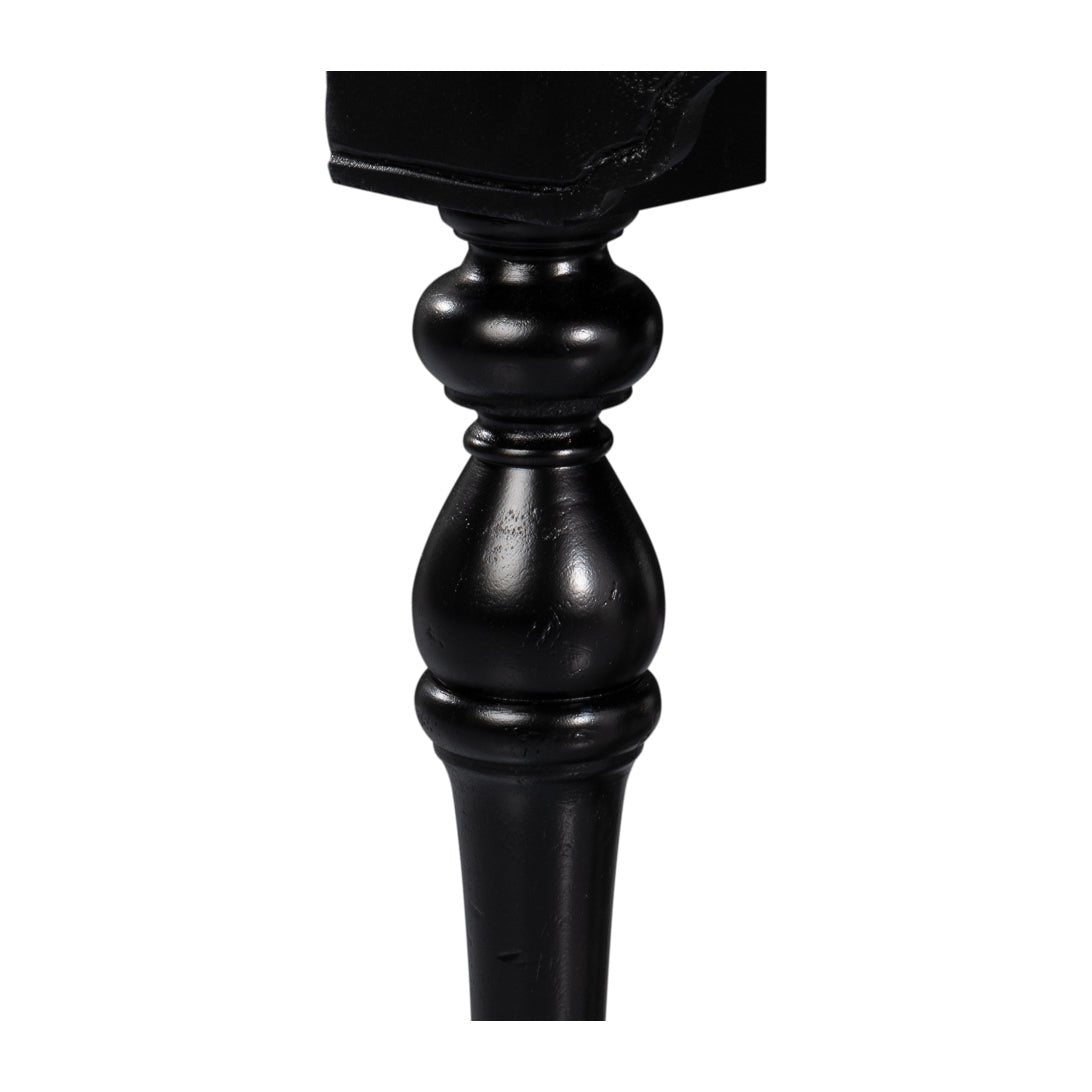 Turned leg detail of black console table, close-up.