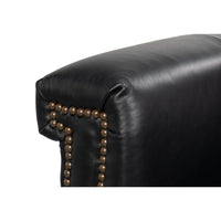 Close-up of armrest studs on leather accent chair.