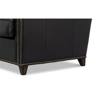 Side base detail with studs on leather accent chair.