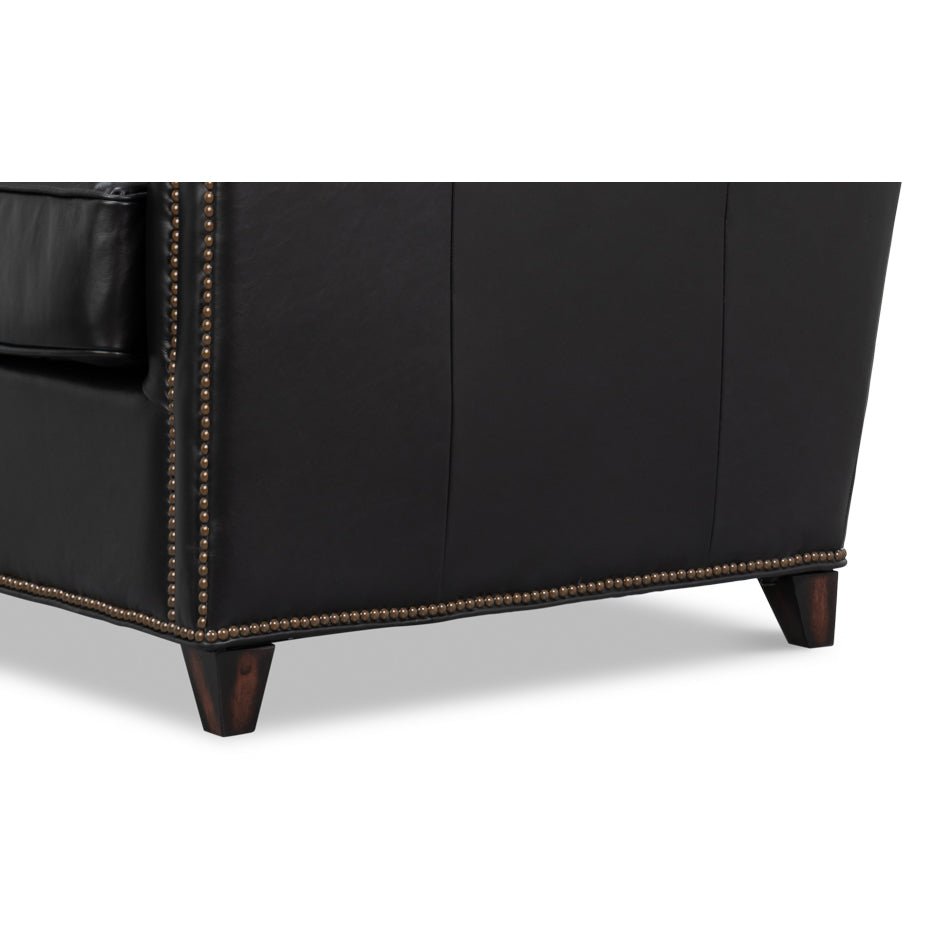 Side base detail with studs on leather accent chair.